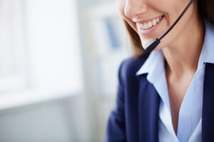 A smiling businesswoman in a blazer looks at her laptop, representing the convenience and accessibility of online legal services.